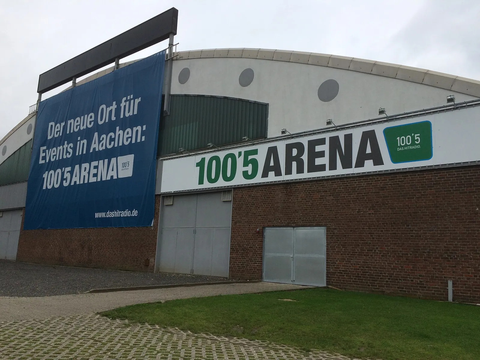 The 100,5 Arena in Aachen with its lettering above the brick entrance wall. — 100,5 Arena