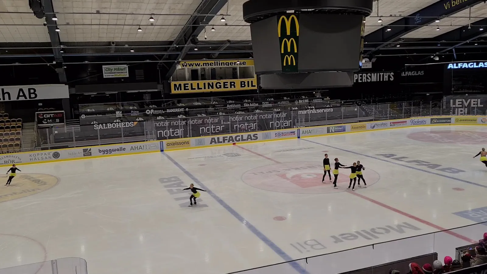 The ice in ABB Arena Nord with a few skaters on it, seen from the stands — ABB Arena Nord