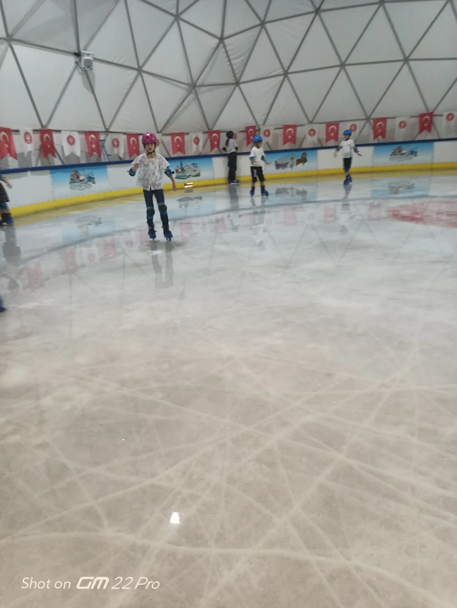 Children skating on the ice under the dome of the Ahmet Çalık rink — Ahmet Çalık Buz Pateni Pisti