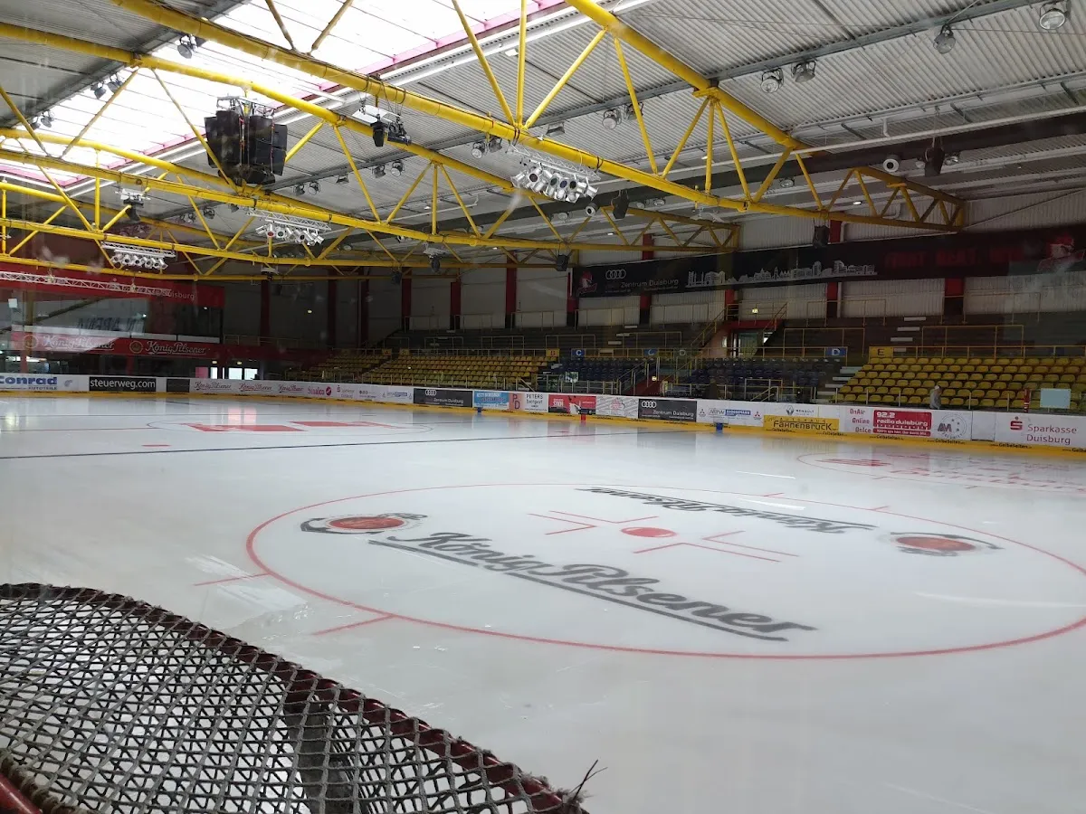 The empty ice and yellow seating of the alleato Arena in Duisburg. — alleato Arena