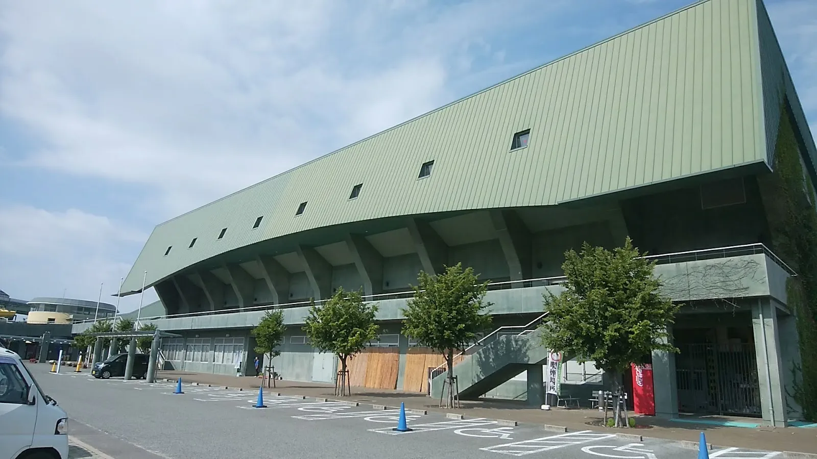 The green-roofed main hall of the Amagasaki Sports Forest seen from the car park; the winter ice rink is laid in its main pool hall — Amagasaki Sports Forest Ice Rink