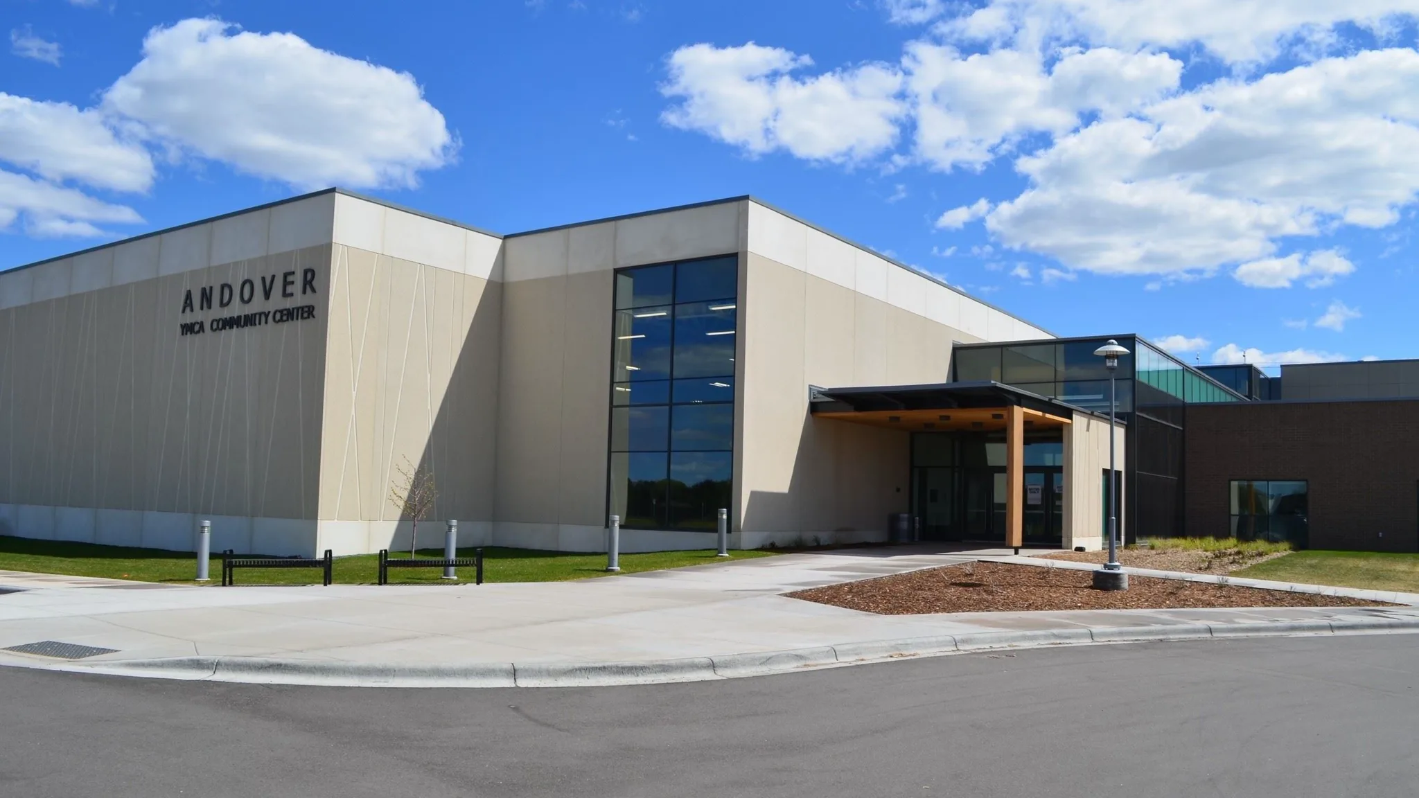 Modern tan precast-concrete building with a tall glazed corner window — Andover Community Center