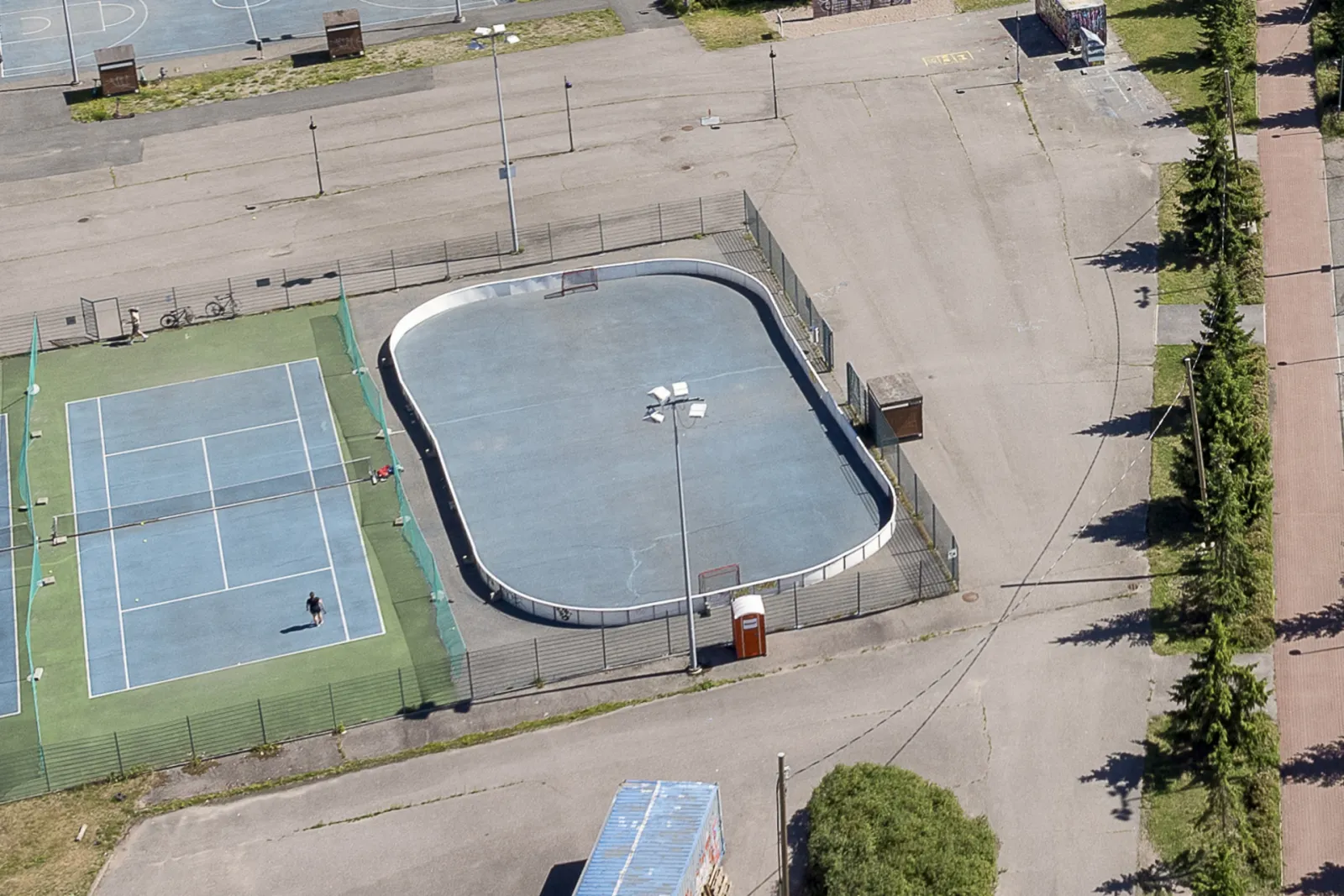 Ilmakuva Arabianrannan liikuntapuiston kaukalosta kesällä, vieressä tenniskenttä – Arabianrannan liikuntapuisto – kaukalo