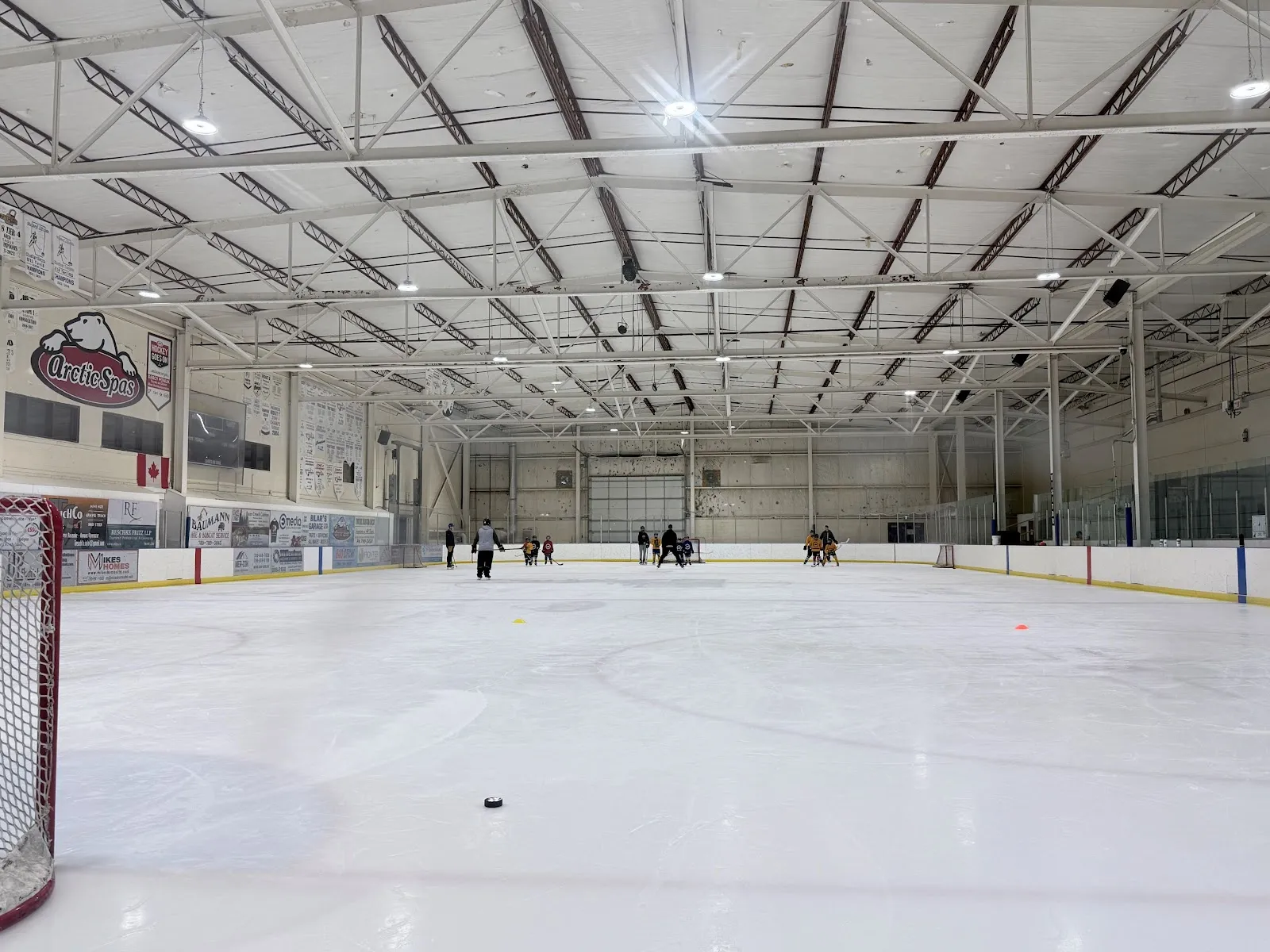 La pista de la arena desde detrás de una portería, mirando a lo largo del hielo hacia las bardas del fondo y el logotipo de Arctic Spas. — Arctic Spas Recreation Complex
