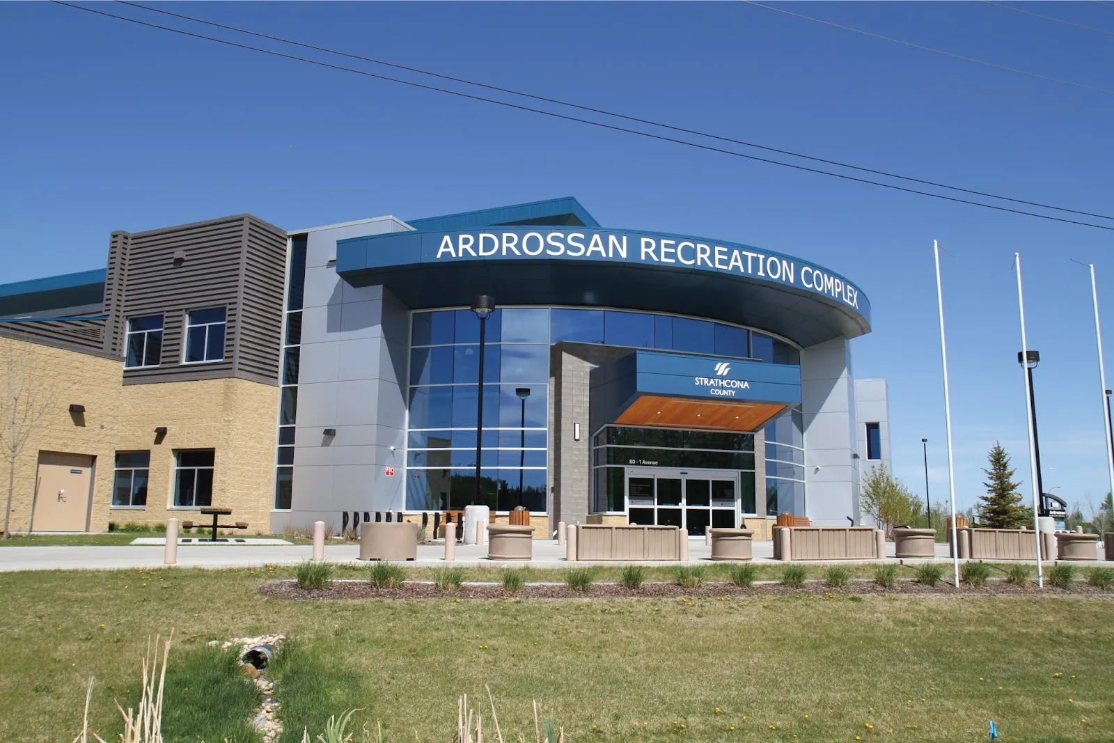 The glass front of the Ardrossan Recreation Complex, its name in white letters across the curved entrance. — Ardrossan Recreation Complex