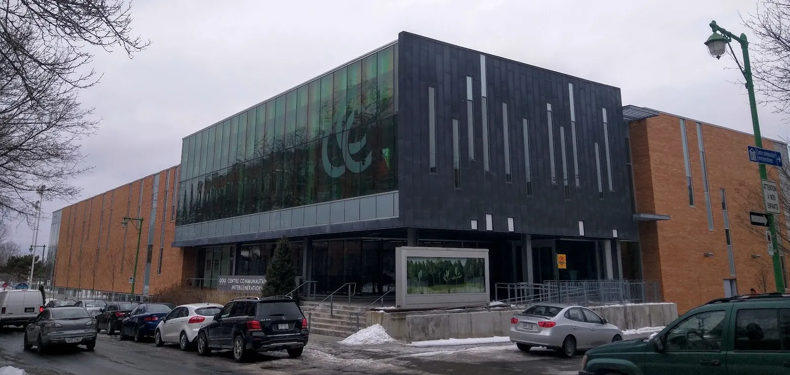The Centre communautaire intergénérationnel at 999 avenue McEachran, which houses the arena: a dark glass block beside long brick wings — Aréna André-Laperrière