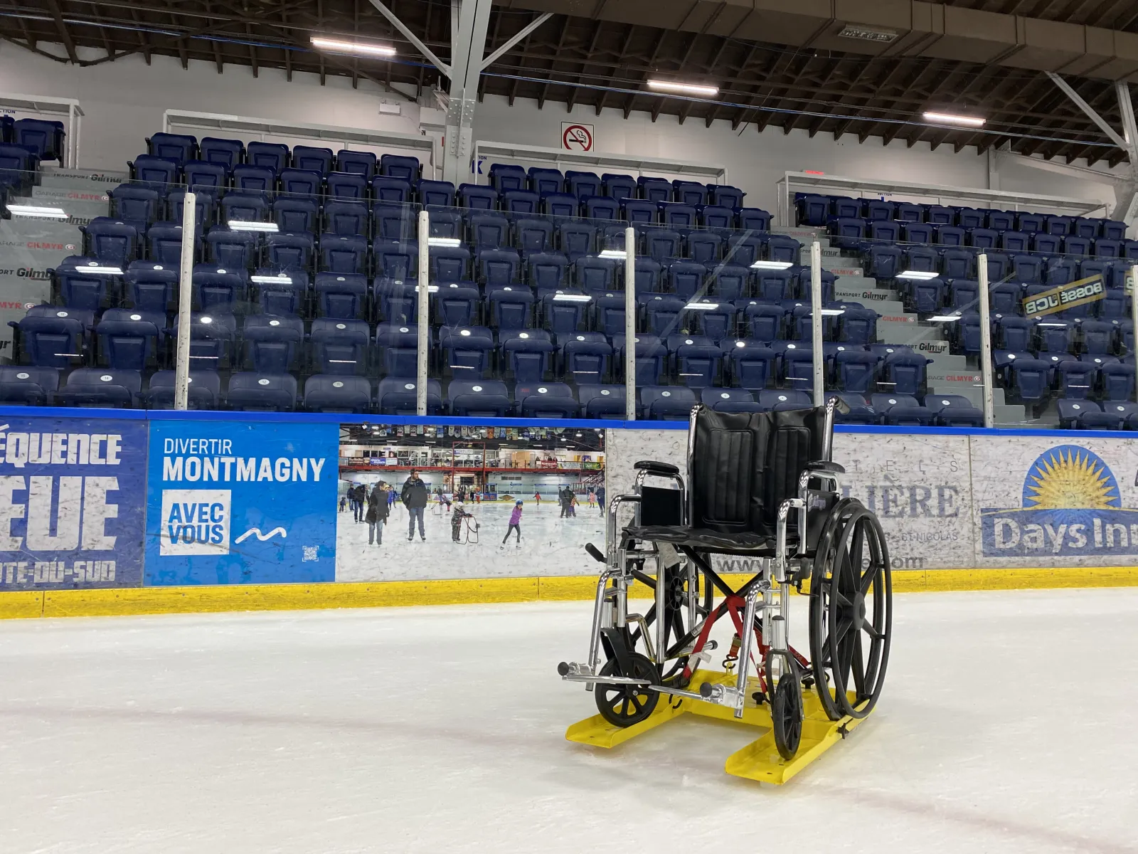 Un trineo Adapto-glace para sillas de ruedas en el hielo frente a las gradas; la ciudad lo presta gratis a patinadores con movilidad reducida. — Aréna de Montmagny