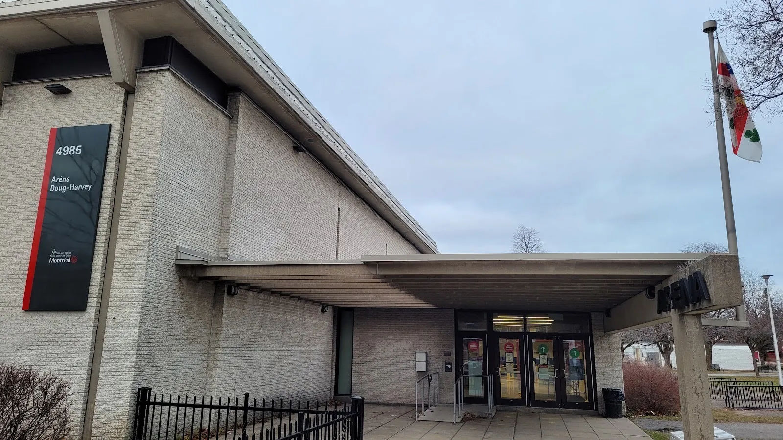 The Aréna Doug-Harvey entrance at 4985 avenue West Hill: the brick hall with its city sign, the flat canopy over the doors and the Aréna post — Aréna Doug-Harvey