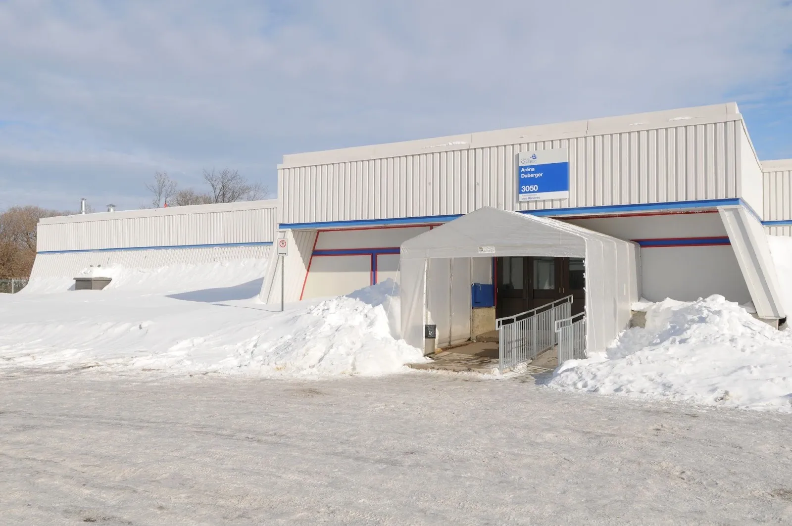 The Aréna Duberger on boulevard Central in Québec in winter, with the City's name and number sign above the entrance — Aréna Duberger