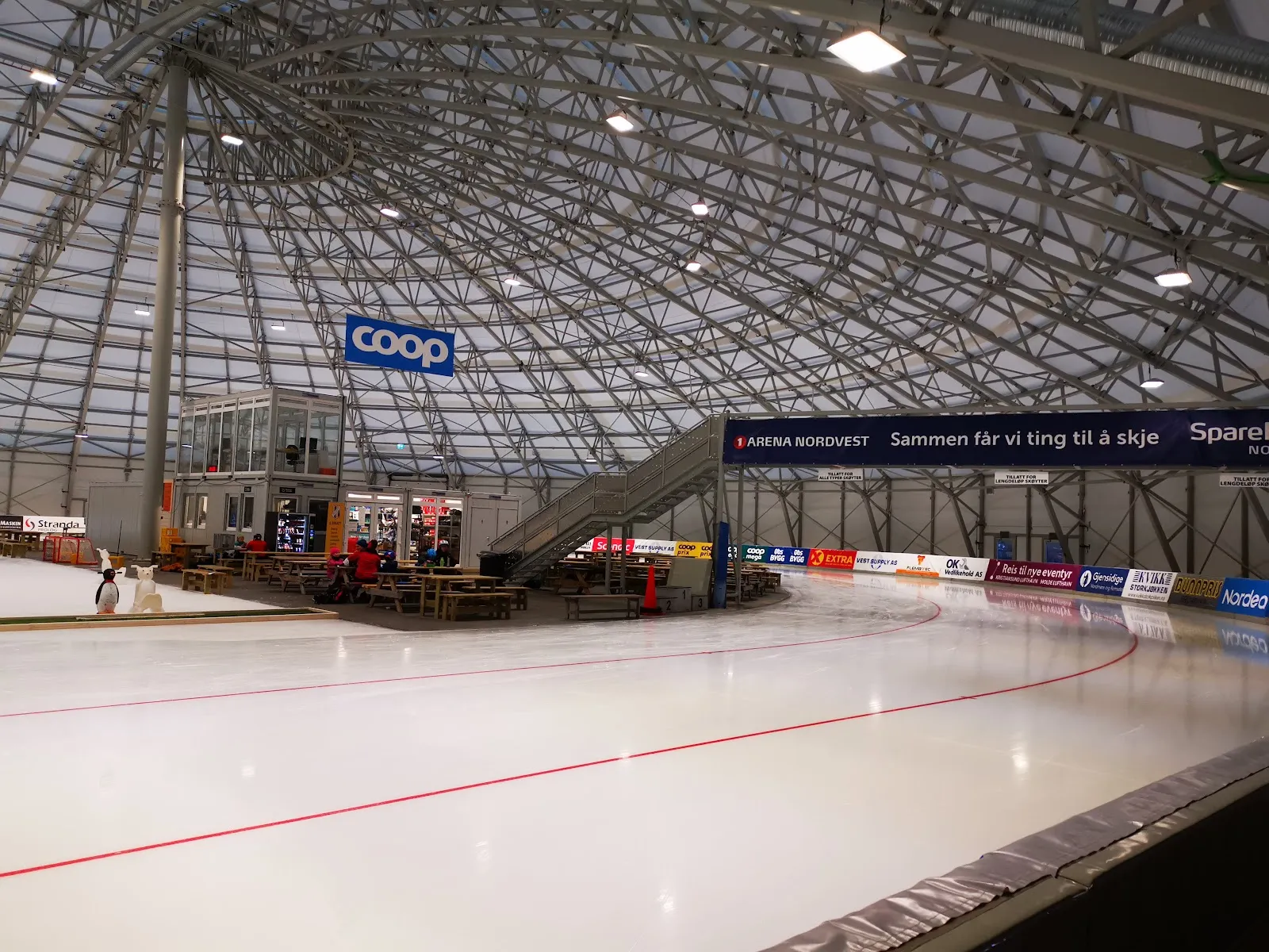 The 400 m ice oval under the steel-lattice roof of Arena Nordvest, with the red lane lines — Arena Nordvest