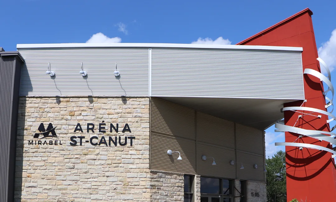 The entrance front of the Aréna Saint-Canut in Mirabel, with its stone base and Mirabel sign. — Aréna Saint-Canut (Mirabel)