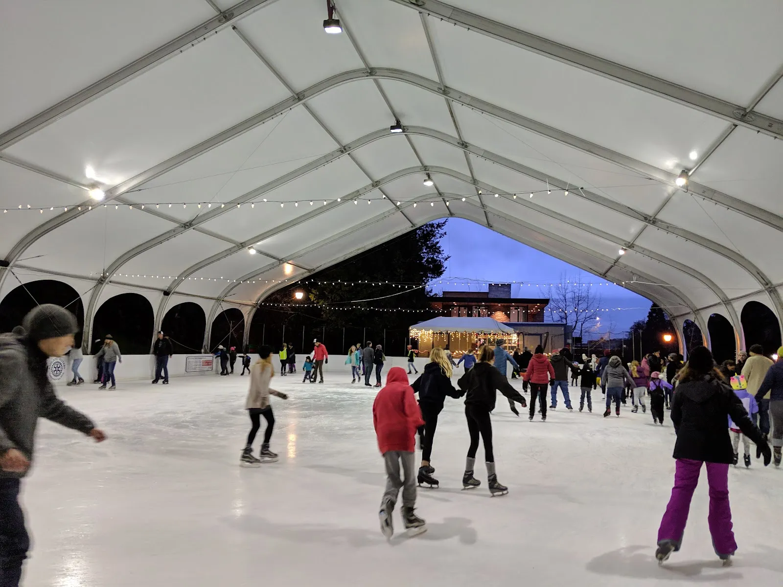 Patinadores en el hielo bajo la carpa blanca de la Ashland Rotary Centennial Ice Rink. — Ashland Rotary Centennial Ice Rink