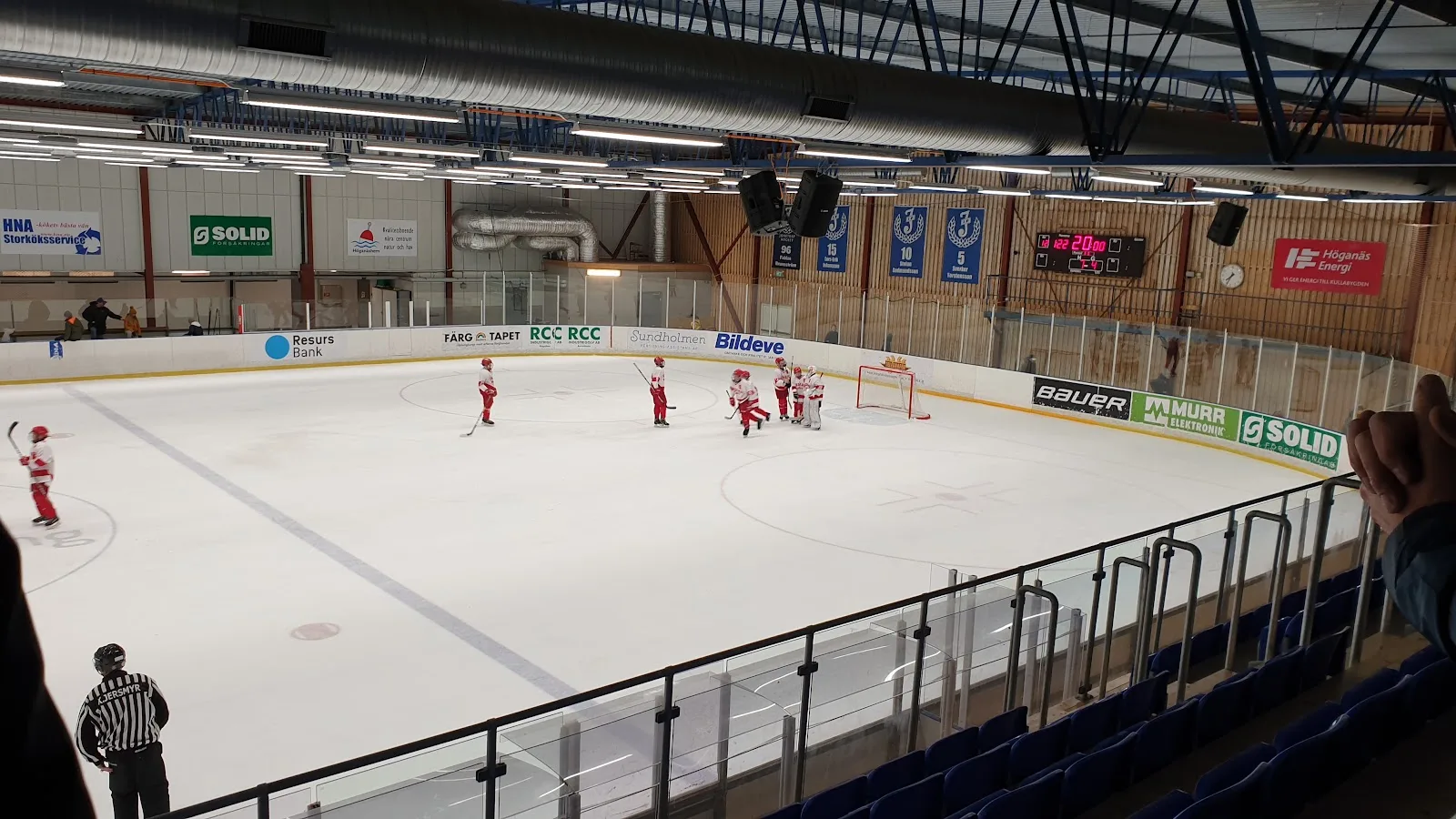 Spelare utspridda över den vita isen i Åstorps ishall under en juniormatch, sedd från läktaren (foto från Google Maps-listningen). – Åstorps ishall