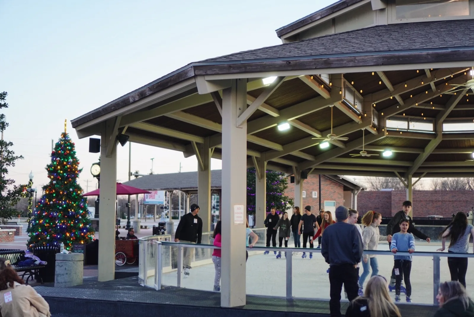 La pista BA Ice Rink bajo el Farmer's Market Pavilion, en el Rose District, con el árbol navideño al lado. — BA Ice Rink