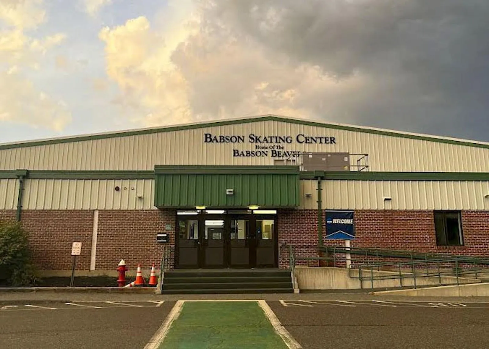 El Babson Skating Center en Wellesley, con su nombre en letras sobre la marquesina verde de la entrada, bajo un cielo de atardecer — Babson Skating Center