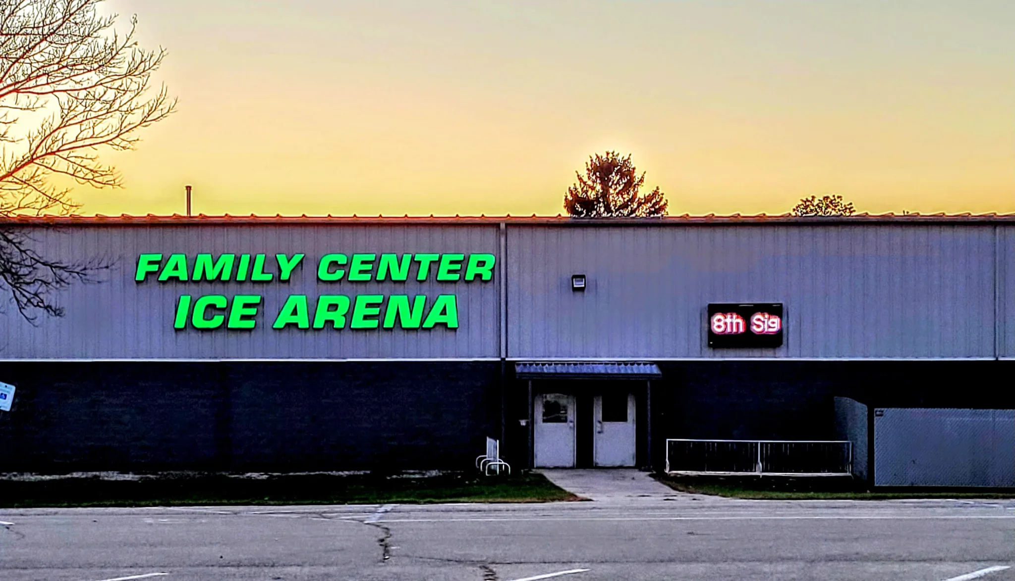 Letrero de Family Center Ice Arena iluminado en verde contra el cielo del atardecer — Beaver Dam Family Center Ice Arena