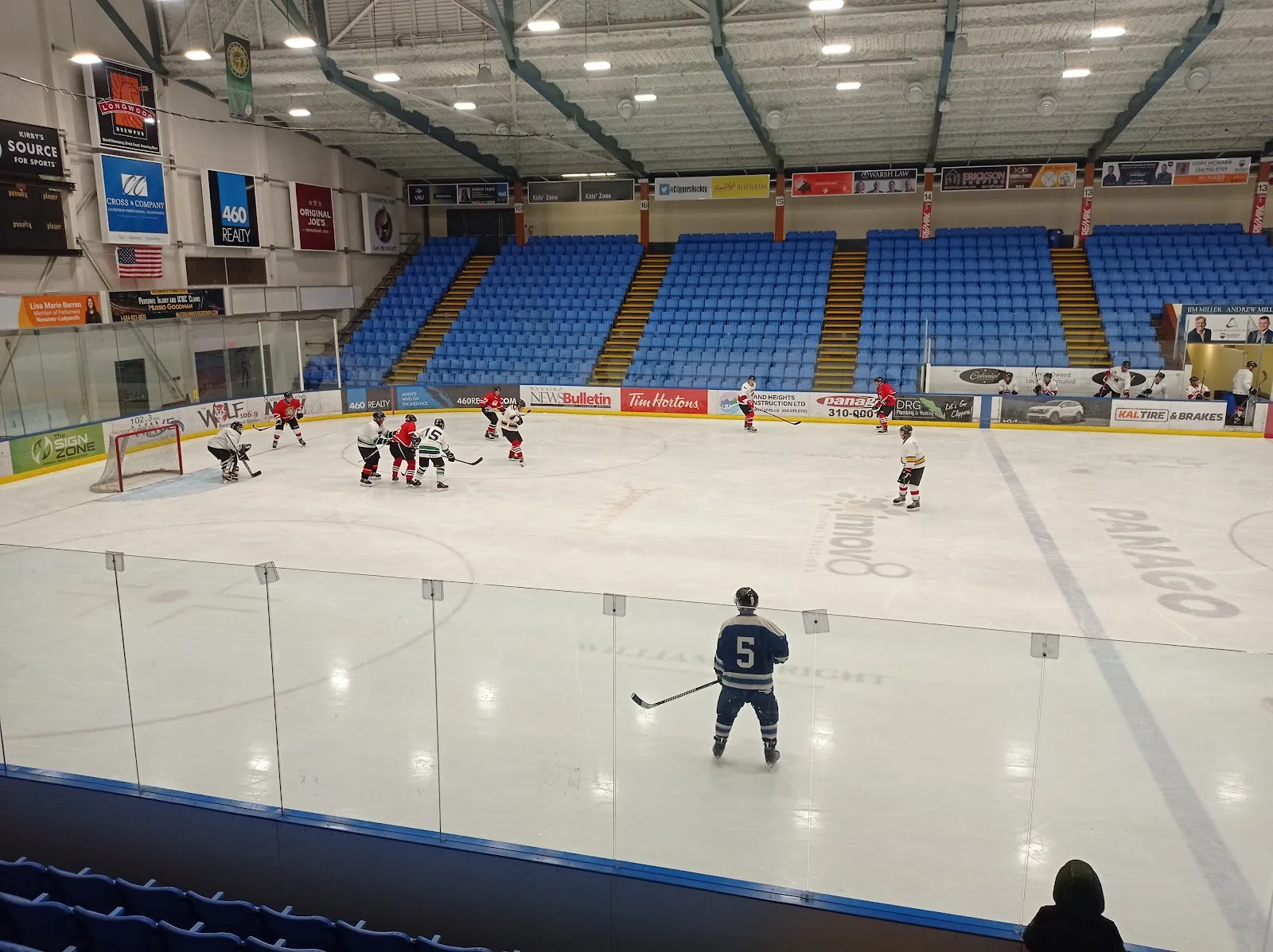 Hielo y gradas azules del Frank Crane Arena durante un partido, vistos desde el cristal — Frank Crane Arena and Cliff McNabb Arena (Beban Park)