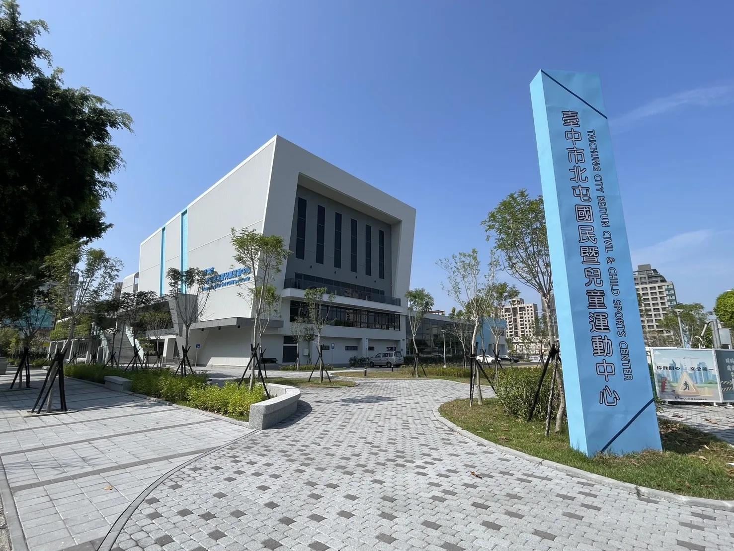 The Beitun Civil and Child Sports Center building and its blue name pillar, which holds the ice rink, seen from the paved forecourt. — Beitun Sports Center Ice Land