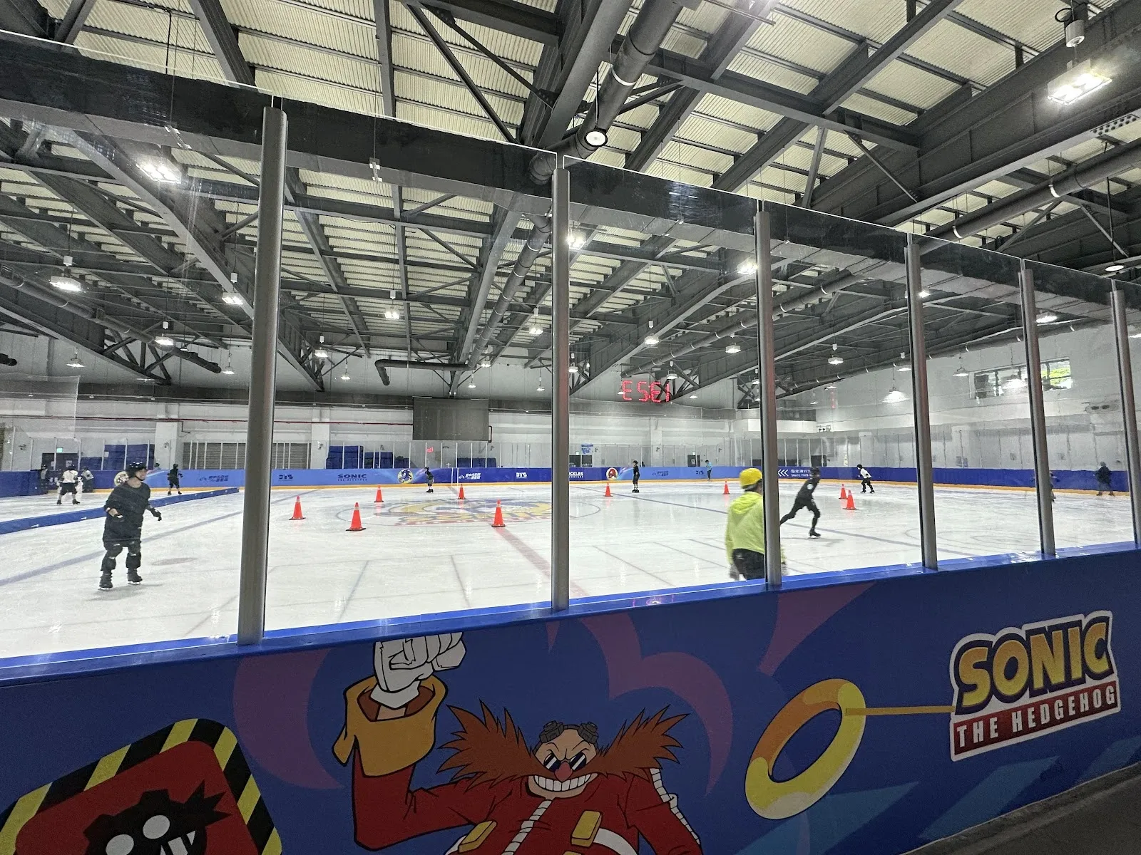 The ice sheet of the Beitun Sports Center Ice Land in Taichung seen from the stands, with the white steel roof and the bright rink-side boards. — Beitun Sports Center Ice Land