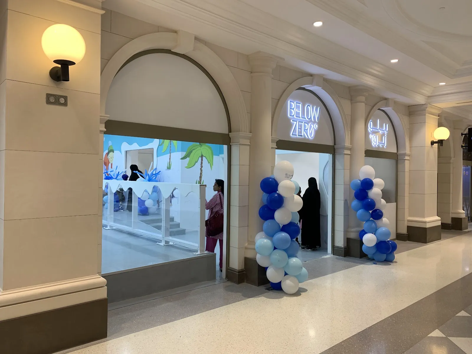 The glazed entrance of Below Zero on a mall corridor in The Avenues, decorated with blue balloons — Below Zero (The Avenues Mall)