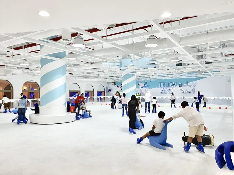 The Below Zero ice sheet in The Avenues with skaters spread across a white rink under a bright ceiling — Below Zero (The Avenues Mall)
