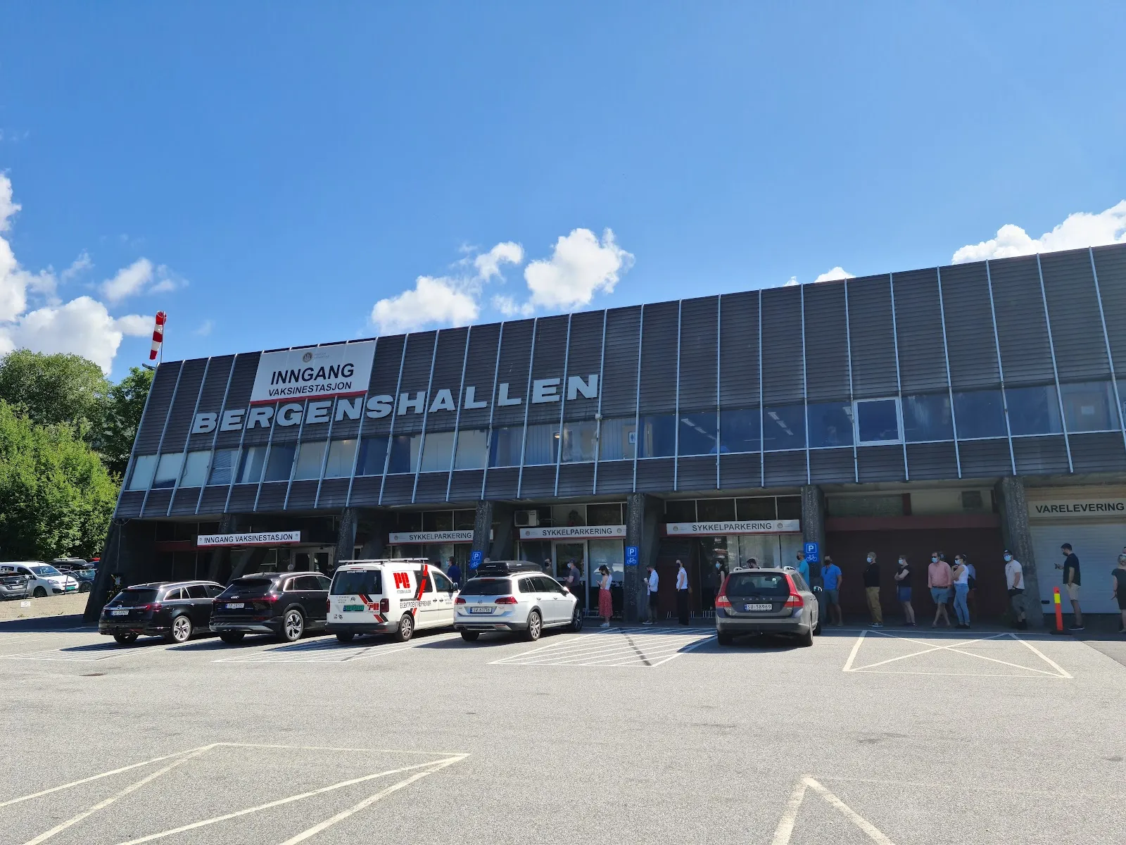 The long glazed front of Bergenshallen with its name in large letters above the entrances and a car park in front. — Bergenshallen