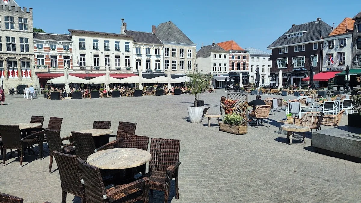 The Grote Markt of Bergen op Zoom on a sunny day, the cobbled square lined with historic gabled houses and terraces where the Bergs Winterparadijs rink is built each winter (the photo shows the square without the rink) — Bergs Winterparadijs