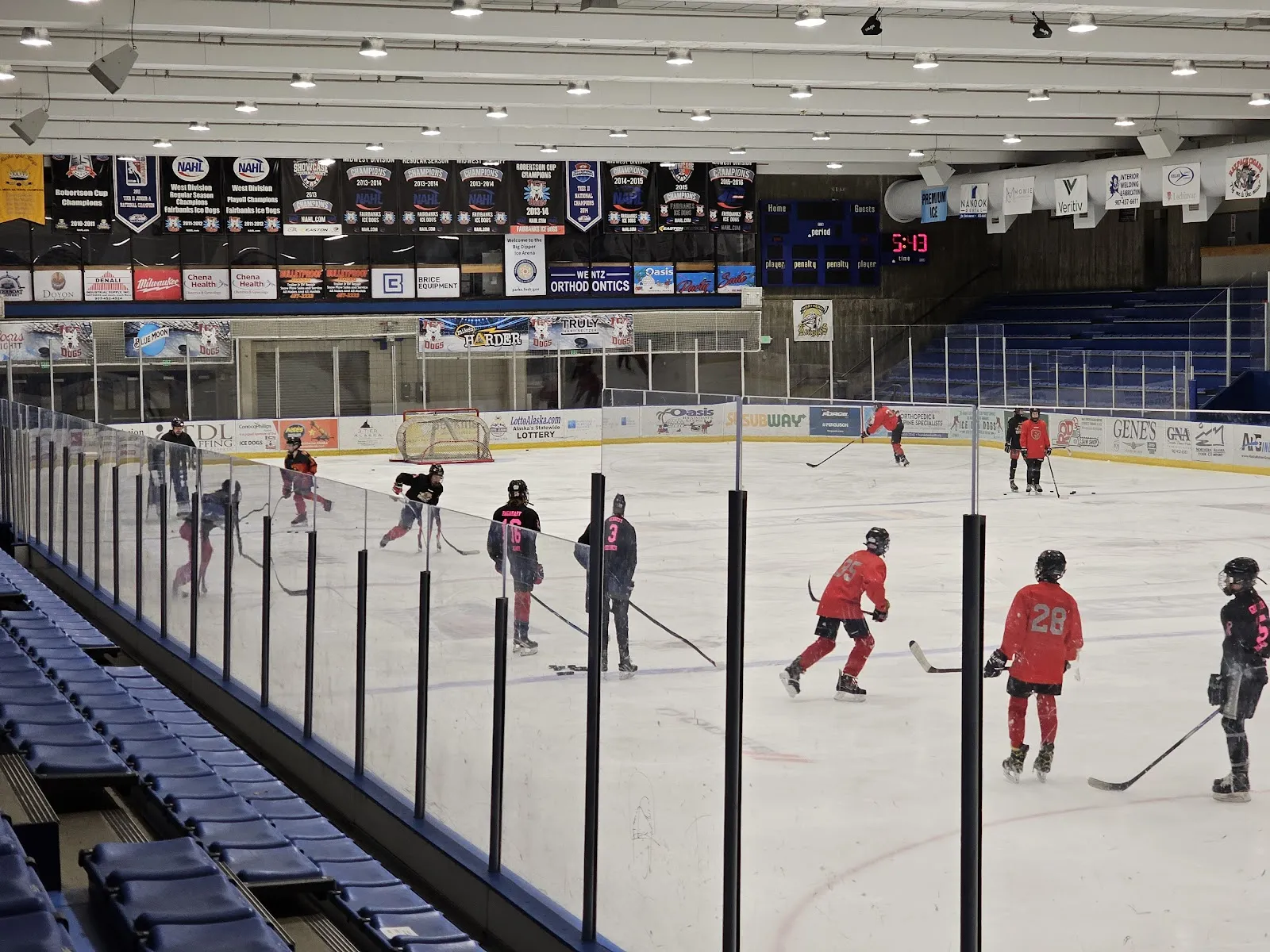 The ice at Big Dipper Ice Arena with the bleachers and championship banners above the boards. — Big Dipper Ice Arena