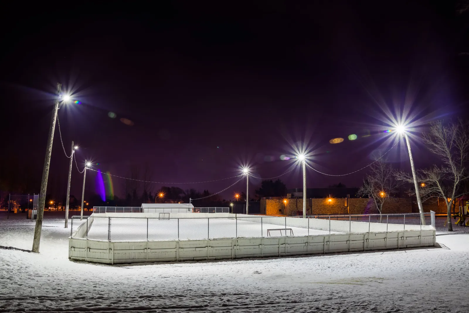 El hielo de la pista comunitaria de Wildwood bajo las luces (página de la pista de la Wildwood Community Association) — Bishop Pocock School Outdoor Rink (Wildwood)