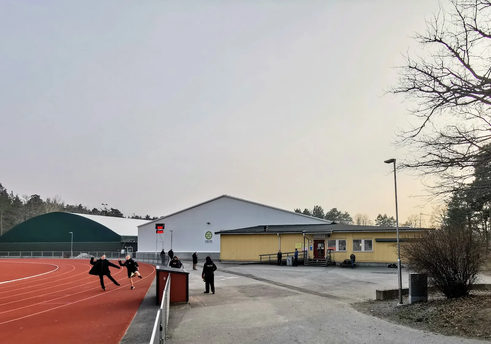 The green ice tent (left) beside the buildings of Björknäs idrottsplats — Björknäs istält