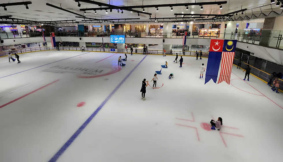 The sheet at Paradigm Mall Johor Bahru seen from the gallery, with the Paradigm logo in the ice and a few skaters at the far side. — Blue Ice Skating Rink Paradigm Mall Johor Bahru