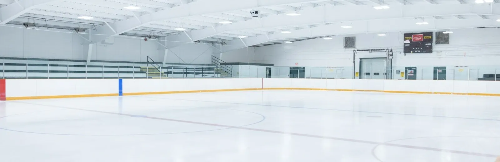 El hielo vacío de Bo Horvat con sus vallas nuevas, el marcador y las bancas a lo largo del lado opuesto. — Bo Horvat Community Centre (West Lorne)