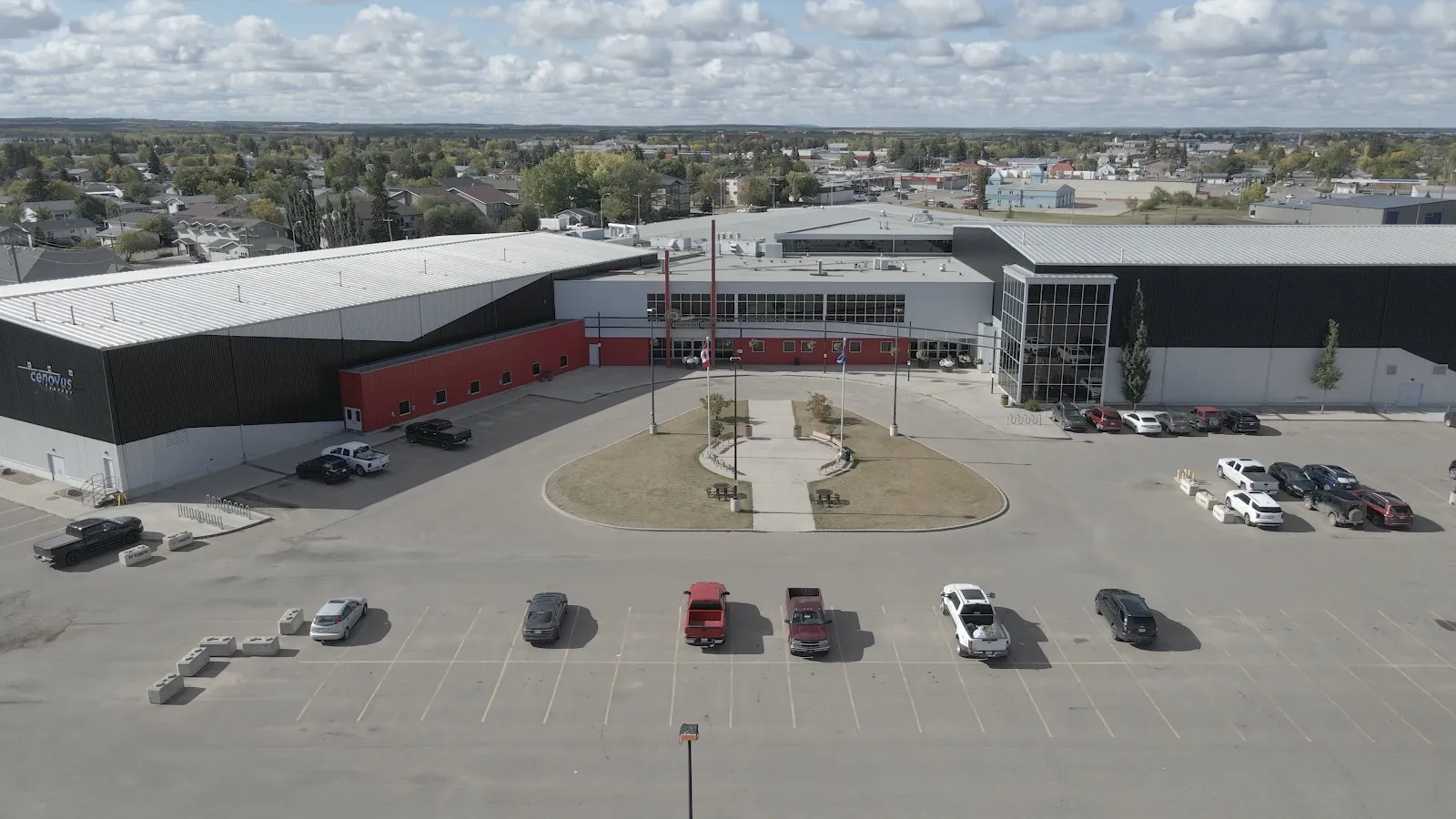 Una vista aérea del Bonnyville & District Centennial Centre en 50 Avenue, con su ala de la arena, su entrada de vidrio y la plaza frontal — Bonnyville & District Centennial Centre