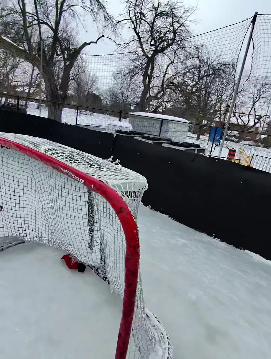 Una portería de hockey y vallas en la pista al aire libre de Boreham Park cubierta de nieve — Boreham Park Outdoor Skating Rink