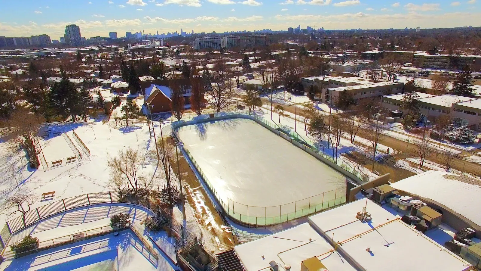 Aerial view of the Broadlands Community Centre outdoor rink in winter, boards and ice surface beside the centre — Broadlands Community Centre Outdoor Ice Rink