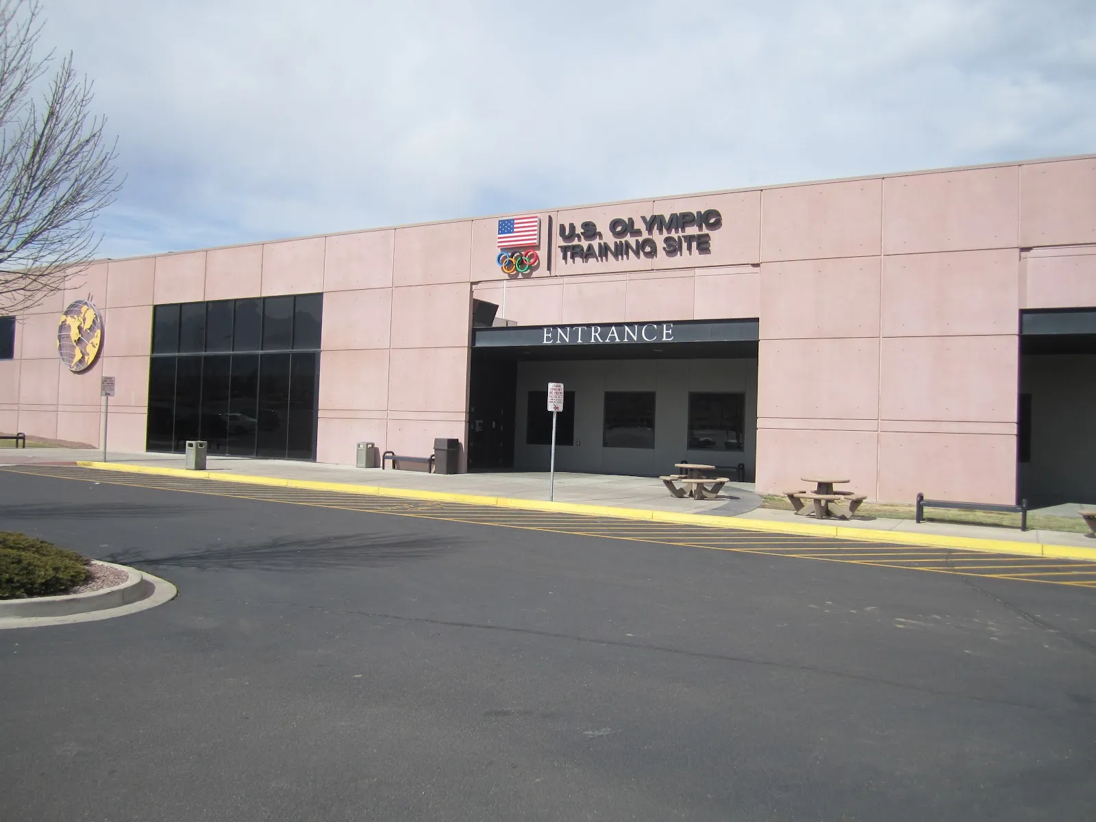 The Ice Hall's pink-panel entrance front with the U.S. Olympic Training Site sign above the entrance canopy. — Broadmoor World Arena Ice Hall