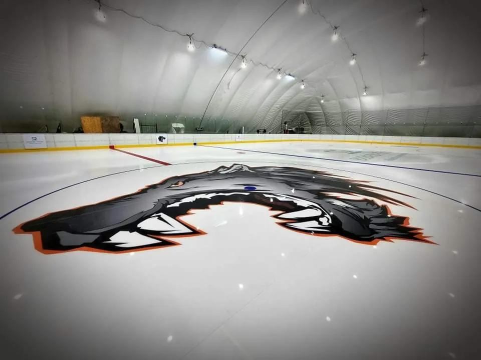 The ice under the tent roof of the Budafoki Jégsátor, with the club's wolf logo at centre ice — Budafoki Jégsátor (Dél-Budai Jég- és Szabadidő Centrum)