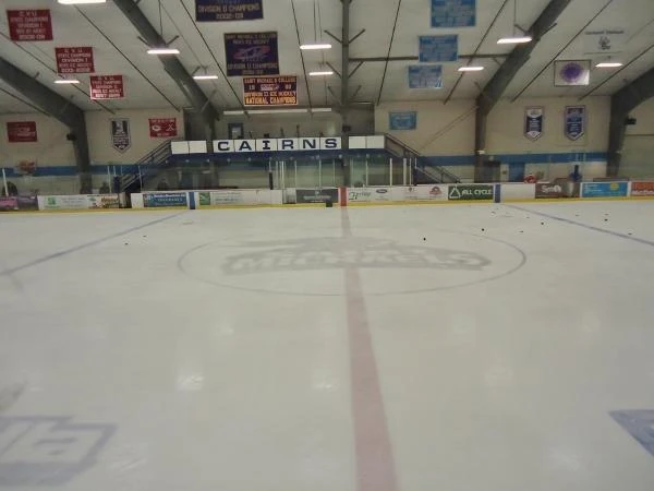 Center ice and the Cairns name above the far-end boards. — Cairns Recreation Arena