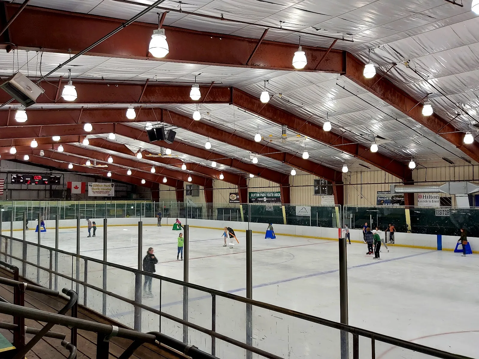 Public skating on the ice sheet at Clifton Park ice arena, skaters along the boards seen from the stands — Capital Arena