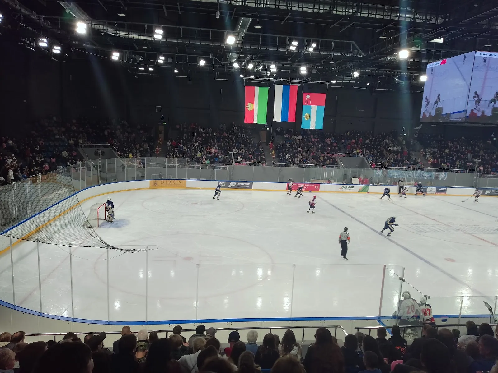 The ice hall of the Kaluga Dvorets Sporta during a hockey match, seen from the stands with the video cube above the ice — Central Sports Palace Kaluga