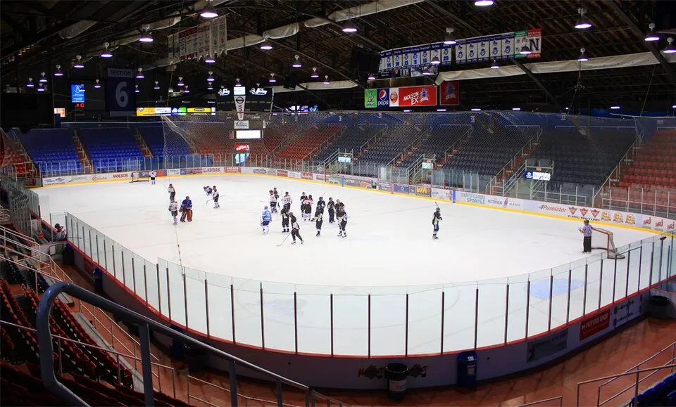 Des patineurs sur la glace du Centre Georges-Vézina, avec les gradins derrière. — Centre Georges-Vézina
