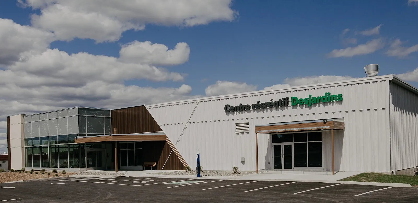 La façade de métal blanc du Centre récréatif Desjardins à Saint-Prosper, avec son nom en lettres vertes et une entrée vitrée — Centre récréatif Desjardins de Saint-Prosper