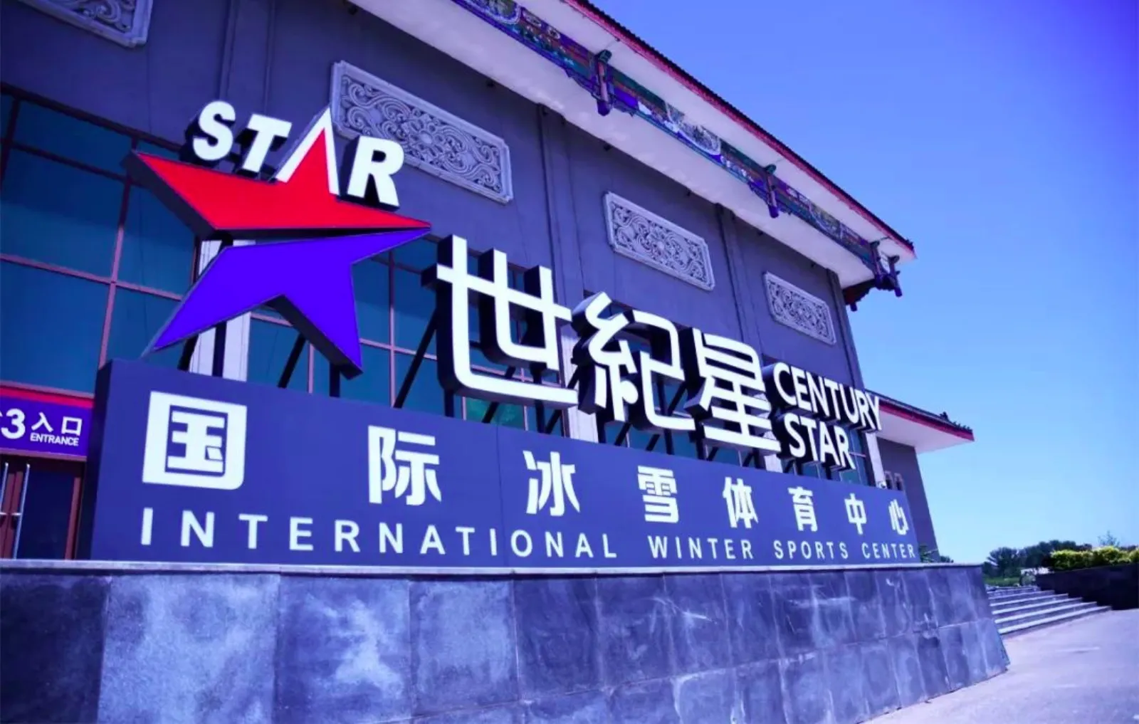 The entrance sign of Century Star International Winter Sports Center, with the centre's name in Chinese and English on a stone base — Century Star International Winter Sports Center