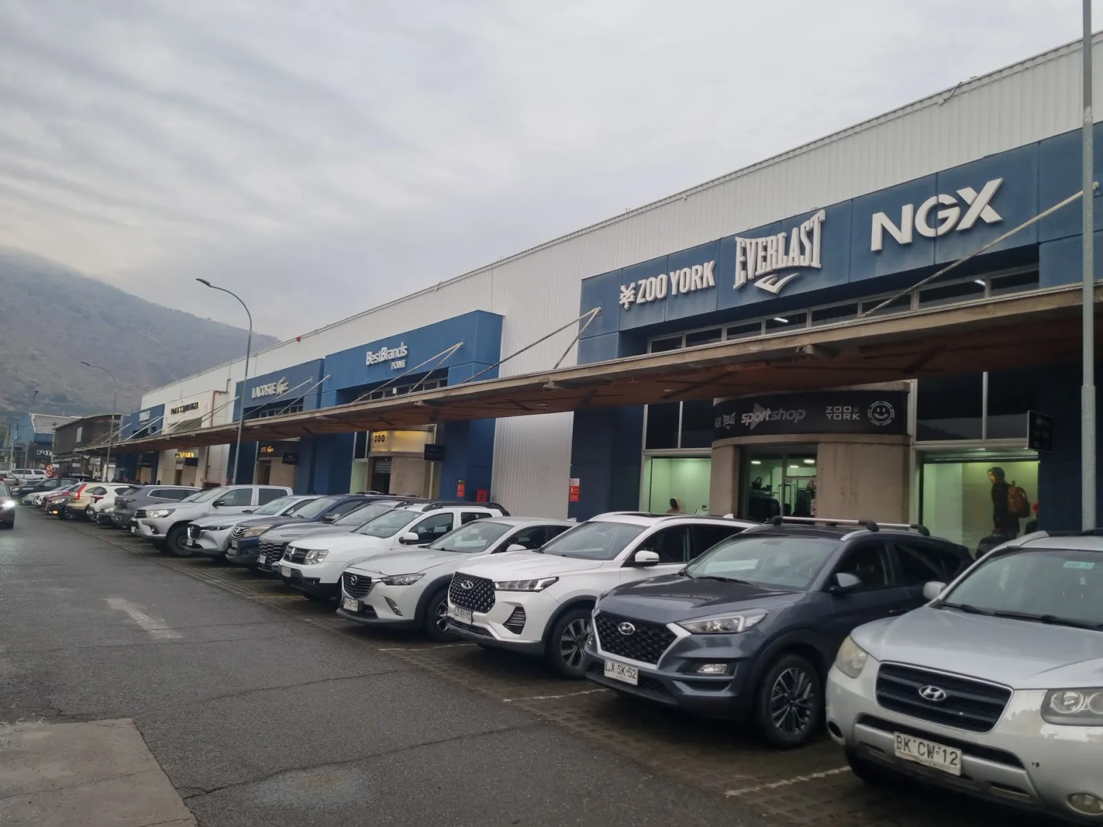 La hilera de tiendas outlet a lo largo del estacionamiento de Arauco Premium Outlet Buenaventura, el centro comercial que alberga la pista Cerogrado — Cerogrado Arauco Buenaventura (Quilicura)