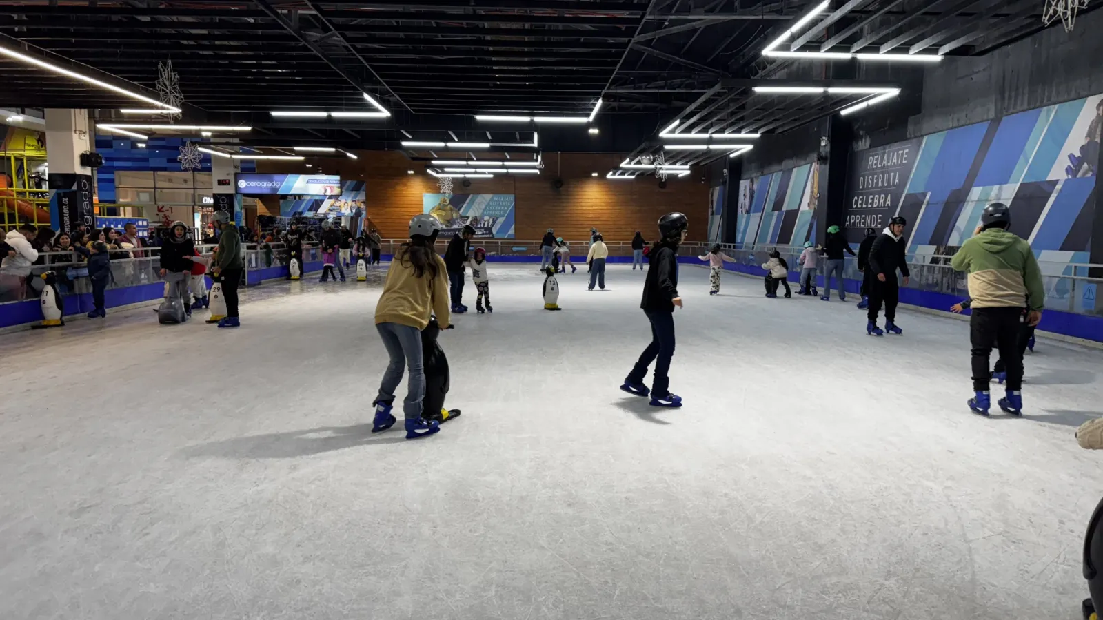 The ice sheet in Mallplaza Bío Bío with skaters spread out and the wood-clad wall of the Trampoline Park behind — Cerogrado Mallplaza Bío Bío (Concepción)