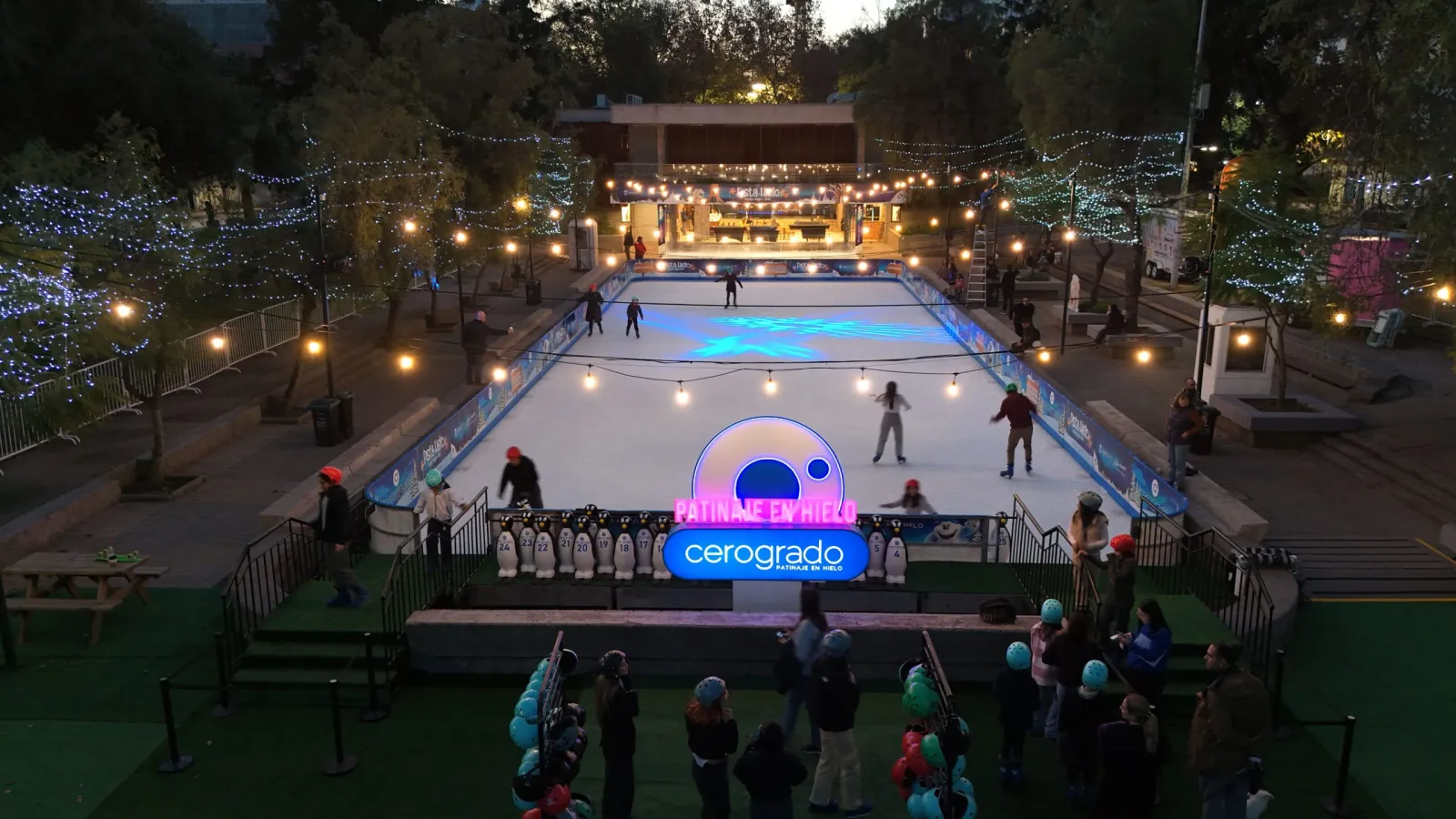 La pista de hielo en el Parque Bustamante al atardecer, con las luces de cadena y el letrero de Cerogrado — Cerogrado Parque Bustamante (Providencia)
