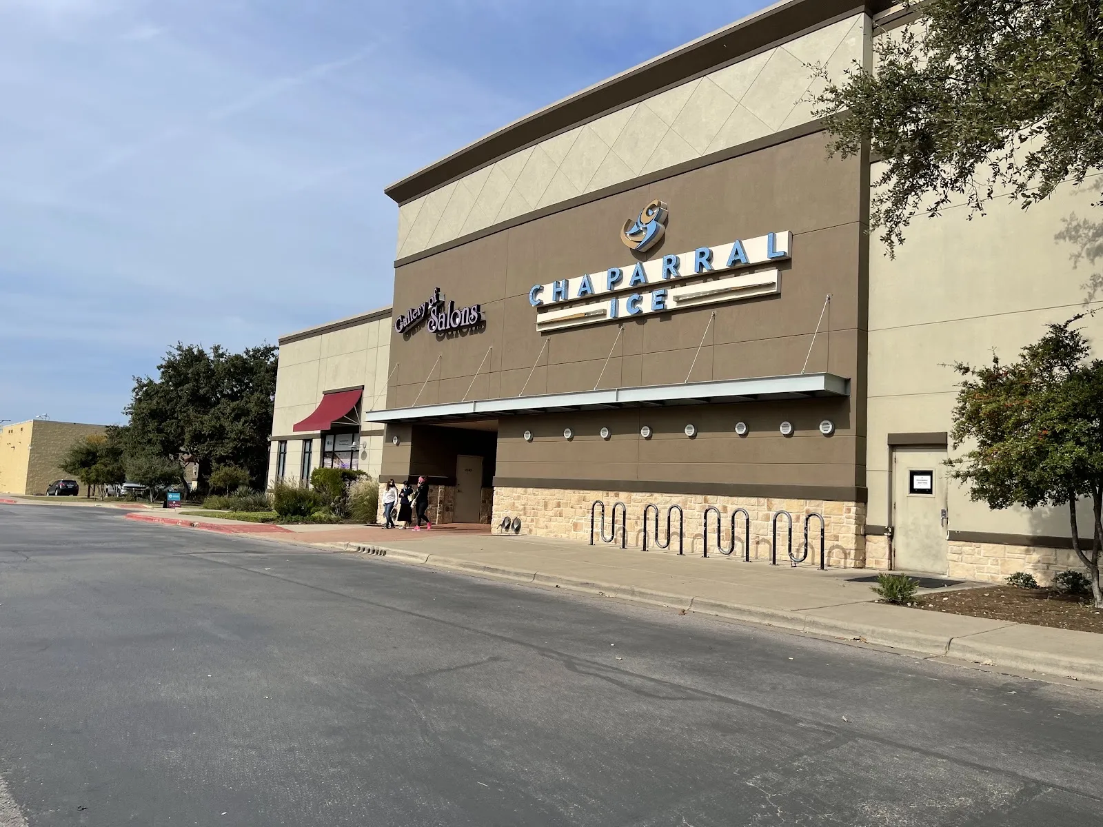 The Chaparral Ice storefront at Northcross, its name in blue letters on a brown facade above a long awning and bike racks — Chaparral Ice at Northcross