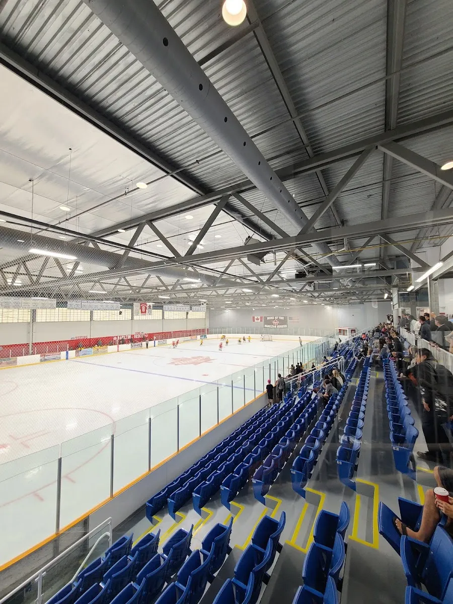 One of the two pads seen from the upper end of the blue seating, under exposed steel trusses. — Chedoke Twin Pad Arena