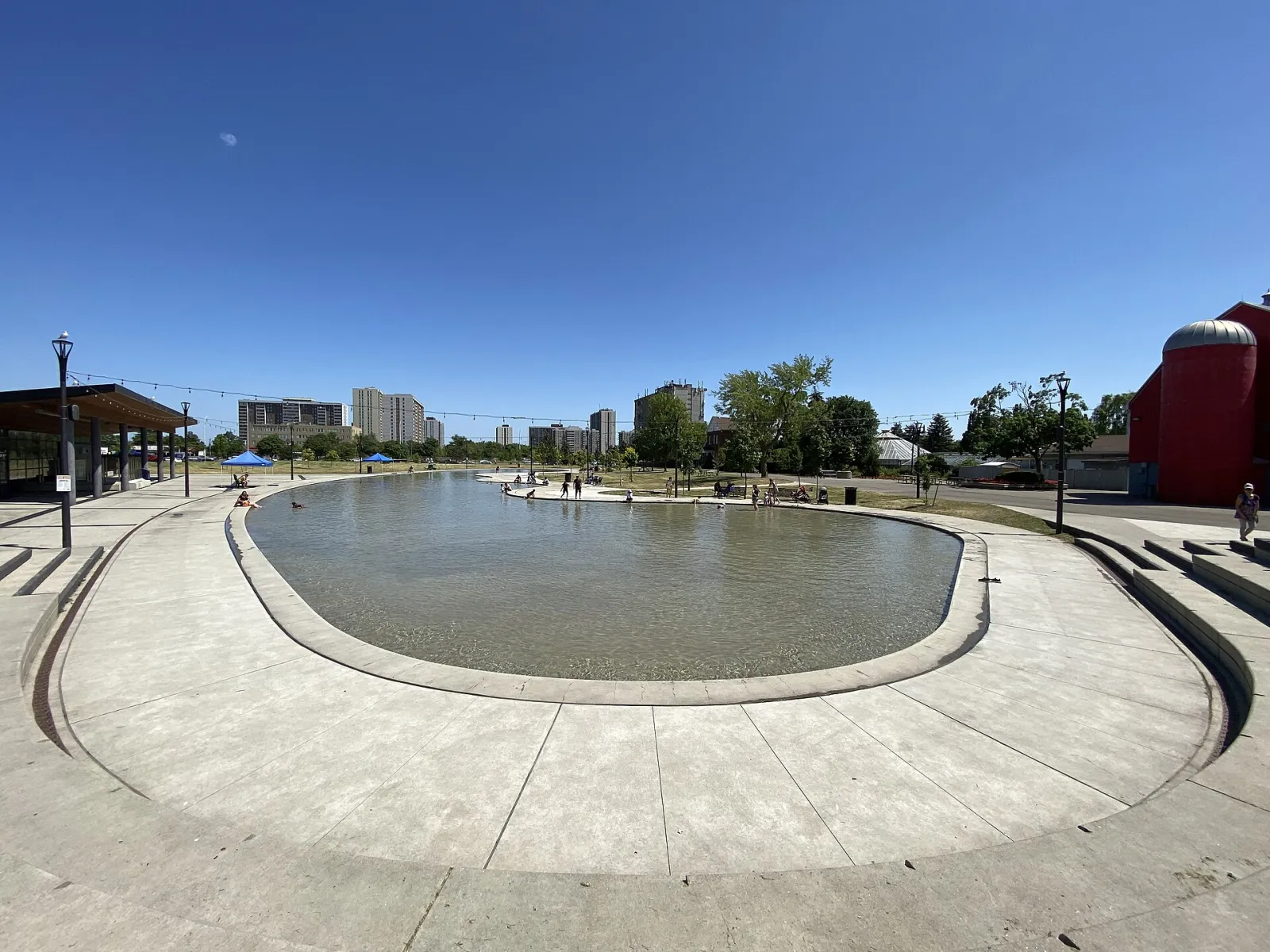 El circuito de patinaje de Chinguacousy Park en verano, cuando funciona como chapoteadero, con los edificios del parque detrás — Chinguacousy Park Skating Trail