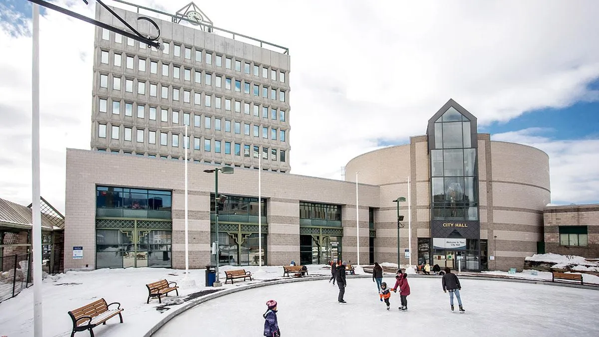 The outdoor rink at Circle at the Centre in front of Barrie City Hall, with skaters on the ice and benches around the edge. — Circle at the Centre Ice Rink (Barrie)